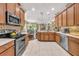 Well-lit kitchen boasts stainless steel appliances, wood cabinets, and a view into the dining room at 14025 Oasis Springs Ln # 901, Windermere, FL 34786