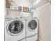 Laundry room featuring white washer and dryer sets with wire shelf and storage at 14025 Oasis Springs Ln # 901, Windermere, FL 34786
