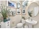 Charming powder room with decorative mirror, botanical art prints, and ample counter space at 14025 Oasis Springs Ln # 901, Windermere, FL 34786