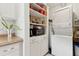 Bright kitchen features a stackable washer/dryer and ample storage with open shelving and cabinets at 1432 Selma Ave, Orlando, FL 32825