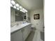 A bright bathroom features white vanity, a large mirror, and neutral decor at 14753 Snowy Egret St, Winter Garden, FL 34787