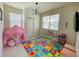 Playful bedroom with colorful ABC rug, cozy play tent, and bright natural light from a large window at 14753 Snowy Egret St, Winter Garden, FL 34787