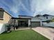 A home with a covered outdoor kitchen, manicured lawn, and driveway at 14753 Snowy Egret St, Winter Garden, FL 34787