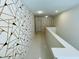 A hallway with white and gold patterned wallpaper, white floors, and white trim at 14753 Snowy Egret St, Winter Garden, FL 34787