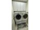 A bright laundry room featuring a washer and dryer, and upper white cabinets for ample storage at 14753 Snowy Egret St, Winter Garden, FL 34787