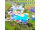 Aerial view of a resort style pool surrounded by palm trees, seating and lush greenery at 14753 Snowy Egret St, Winter Garden, FL 34787