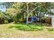 Large backyard with lush greenery, grass, mature trees, and a shed at 174 Pine Grove Ct, Daytona Beach, FL 32119