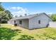 Exterior backyard of a single-story home showcases a well-maintained lawn and white brickwork at 174 Pine Grove Ct, Daytona Beach, FL 32119