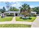 Charming white brick home featuring a well-manicured lawn, inviting walkway, and mature landscaping at 174 Pine Grove Ct, Daytona Beach, FL 32119