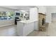 Bright kitchen with white cabinetry, breakfast bar, stainless steel appliances, and a decorative stone fireplace at 174 Pine Grove Ct, Daytona Beach, FL 32119