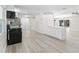 Modern open floorplan featuring a kitchen with bright white cabinets, an island, and wood vinyl flooring at 174 Pine Grove Ct, Daytona Beach, FL 32119
