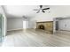 Large open living room with tile floors, a stone fireplace, ceiling fans, and access to the kitchen at 174 Pine Grove Ct, Daytona Beach, FL 32119