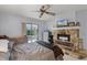 Comfortable bedroom with a stone fireplace, ceiling fan, and sliding glass doors to a patio at 179 Crown Point Cir, Longwood, FL 32779