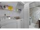 Practical laundry room with washer, dryer, storage shelving, and tile floors at 179 Crown Point Cir, Longwood, FL 32779