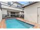 Backyard pool surrounded by brick pavers and a black safety fence with a door leading to the patio at 1943 Majorca Dr, Kissimmee, FL 34747