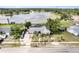 An aerial view of the property with a screened pool, complemented by a serene lake backdrop, and palm-lined driveway at 1962 English Dr, Deltona, FL 32738