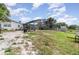 Expansive backyard featuring a screened-in pool enclosure, house, and a mix of grass and sand at 1962 English Dr, Deltona, FL 32738