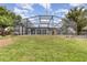 Spacious backyard featuring a screened-in pool enclosure and ample green space at 1962 English Dr, Deltona, FL 32738