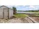 Backyard view with a storage shed, trampoline, landscaping, and a lake view beyond the backyard at 1962 English Dr, Deltona, FL 32738