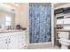 Bathroom featuring a vanity and sink, toilet, shower with a seashell-themed curtain, and storage shelves at 1962 English Dr, Deltona, FL 32738