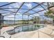A screened-in pool with water in need of cleaning overlooking a tranquil lake in the backyard at 1962 English Dr, Deltona, FL 32738