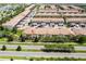 Aerial view of townhomes with well-kept landscaping, palm trees, and community roads and sidewalks at 1979 Majorca Dr, Kissimmee, FL 34747