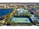 Overhead shot of a basketball court with community center, pool area, houses and pond in the distance at 1979 Majorca Dr, Kissimmee, FL 34747