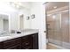 Bathroom featuring double sink vanity with granite countertops and a glass-enclosed shower stall at 1979 Majorca Dr, Kissimmee, FL 34747