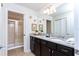 Bathroom featuring double sinks, granite counters, a tiled shower, and sleek modern fixtures at 1979 Majorca Dr, Kissimmee, FL 34747