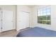 Bright bedroom with a large window, closet, and a door, offering ample space and natural light at 1979 Majorca Dr, Kissimmee, FL 34747
