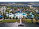 Aerial view of an elaborate community pool area, featuring slides, cabanas, lazy river, and chairs for lounging at 1979 Majorca Dr, Kissimmee, FL 34747