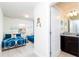 Hallway view leading to a bedroom with blue bedding and an adjacent bathroom with sleek, modern features at 1979 Majorca Dr, Kissimmee, FL 34747