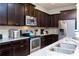 Well-appointed kitchen featuring stainless steel appliances, granite countertops, and dark wood cabinets at 1979 Majorca Dr, Kissimmee, FL 34747