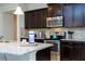 Close-up on kitchen showcasing stainless steel appliances, a large island, and dark wood cabinetry at 1979 Majorca Dr, Kissimmee, FL 34747