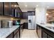Stylish kitchen with stainless steel appliances, dark cabinetry, and a functional layout for cooking at 1979 Majorca Dr, Kissimmee, FL 34747