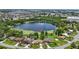 Aerial view of community with a lake surrounded by green trees and houses at 2028 Lake Christie Dr, Orlando, FL 32809