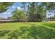 A large backyard featuring a green lawn with a glimpse of the lake at 2028 Lake Christie Dr, Orlando, FL 32809