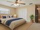 Staged bedroom with neutral walls, carpeted floor, window, and closet with louvered doors at 2028 Lake Christie Dr, Orlando, FL 32809