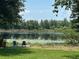 Scenic waterfront view with Adirondack chairs on a dock, offering serene relaxation and beautiful nature at 2028 Lake Christie Dr, Orlando, FL 32809