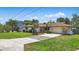 Home exterior with a lush green lawn, palm trees, and a long driveway at 2028 Lake Christie Dr, Orlando, FL 32809