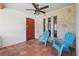 Inviting front porch with blue patio chairs, tile flooring, and a ceiling fan at 2028 Lake Christie Dr, Orlando, FL 32809