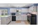 Well-lit kitchen with white cabinets, tiled floors, and black appliances at 2028 Lake Christie Dr, Orlando, FL 32809