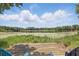 Beautiful lake view with lily pads, trees, and a wooden dock featuring patio chairs at 2028 Lake Christie Dr, Orlando, FL 32809