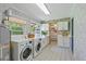 Well-equipped laundry room with modern machines, built-in sink, and ample cabinet space at 2028 Lake Christie Dr, Orlando, FL 32809