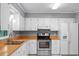 Bright kitchen with white cabinets, stainless steel oven and a wooden countertop with a double stainless steel sink at 216 San Fernando Ct, Sanford, FL 32773