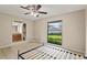 Bedroom with a ceiling fan, neutral walls, large window, and ensuite bathroom featuring tile flooring at 22 Hillcrest Dr, Babson Park, FL 33827