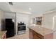 Open concept kitchen with stone countertops and island that opens up to living space with stone fireplace at 22 Hillcrest Dr, Babson Park, FL 33827