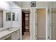 Bright bathroom with modern vanity, mirror and open access to walk-in closet and tiled shower with glass door at 2227 Doulton Dr, Orlando, FL 32812