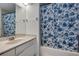This bathroom has a vanity, mirror, and a tub with a blue floral shower curtain at 2227 Doulton Dr, Orlando, FL 32812