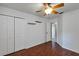 This bedroom features wood floors, a ceiling fan, shelving, and a closet with white doors at 2227 Doulton Dr, Orlando, FL 32812